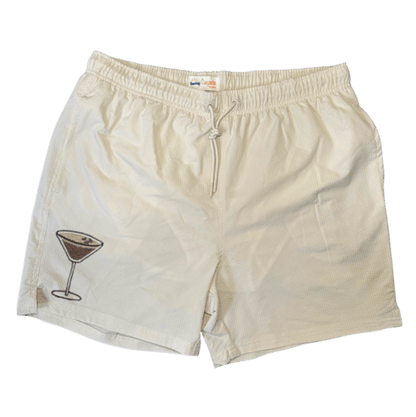 Maillot de plage pour homme couleur beige. Personnalisation du maillot grâce à des broderies. Il faut choisir parmi un choix de broderies dessinées à la main sur le thème de l’été sur la Côte d’Azur dans les Alpes Maritimes, 06. La broderie est brodée sur l’avant du maillot, jambe droite. Toutes les broderies sont faites à la commande selon la personnalisation choisie. Ici, il s’agit de la broderie espresso martini.