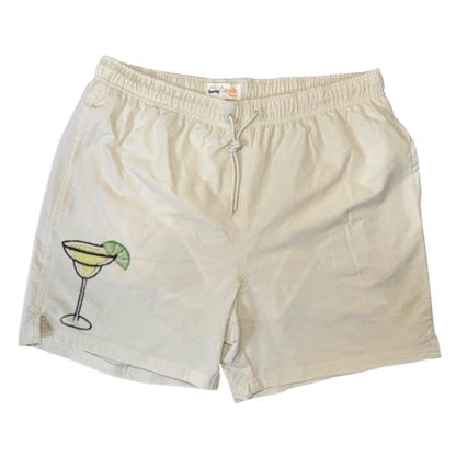 Maillot de plage pour homme couleur beige. Personnalisation du maillot grâce à des broderies. Il faut choisir parmi un choix de broderies dessinées à la main sur le thème de l’été sur la Côte d’Azur dans les Alpes Maritimes, 06. La broderie est brodée sur l’avant du maillot, jambe droite. Toutes les broderies sont faites à la commande selon la personnalisation choisie. Ici, il s’agit de la broderie margarita, cocktail.