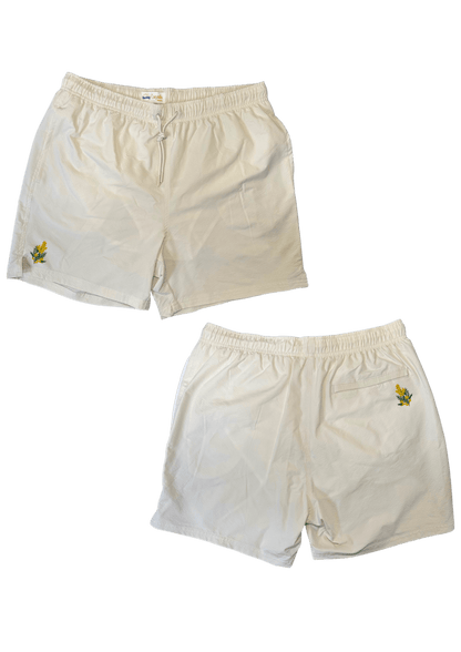 Maillot de plage pour homme couleur beige. Personnalisation du maillot grâce à des broderies. Il faut choisir parmi un choix de broderies dessinées à la main sur le thème de l’été sur la Côte d’Azur dans les Alpes Maritimes, 06. La broderie est brodée sur l’avant du maillot, jambe droite et sur la poche arrière jambe droite. Toutes les broderies sont faites à la commande selon la personnalisation choisie. Ici, il s’agit de la broderie mimosa, jaune et vert.