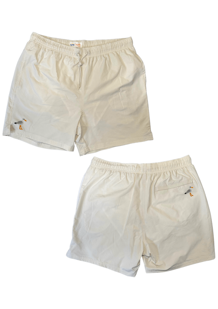 Maillot de plage pour homme couleur beige. Personnalisation du maillot grâce à des broderies. Il faut choisir parmi un choix de broderies dessinées à la main sur le thème de l’été sur la Côte d’Azur dans les Alpes Maritimes, 06. La broderie est brodée sur l’avant du maillot, jambe droite et sur la poche arrière jambe droite. Toutes les broderies sont faites à la commande selon la personnalisation choisie. Ici, il s’agit de la broderie mouette.