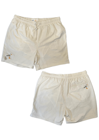 Maillot de plage pour homme couleur beige. Personnalisation du maillot grâce à des broderies. Il faut choisir parmi un choix de broderies dessinées à la main sur le thème de l’été sur la Côte d’Azur dans les Alpes Maritimes, 06. La broderie est brodée sur l’avant du maillot, jambe droite et sur la poche arrière jambe droite. Toutes les broderies sont faites à la commande selon la personnalisation choisie. Ici, il s’agit de la broderie mouette.