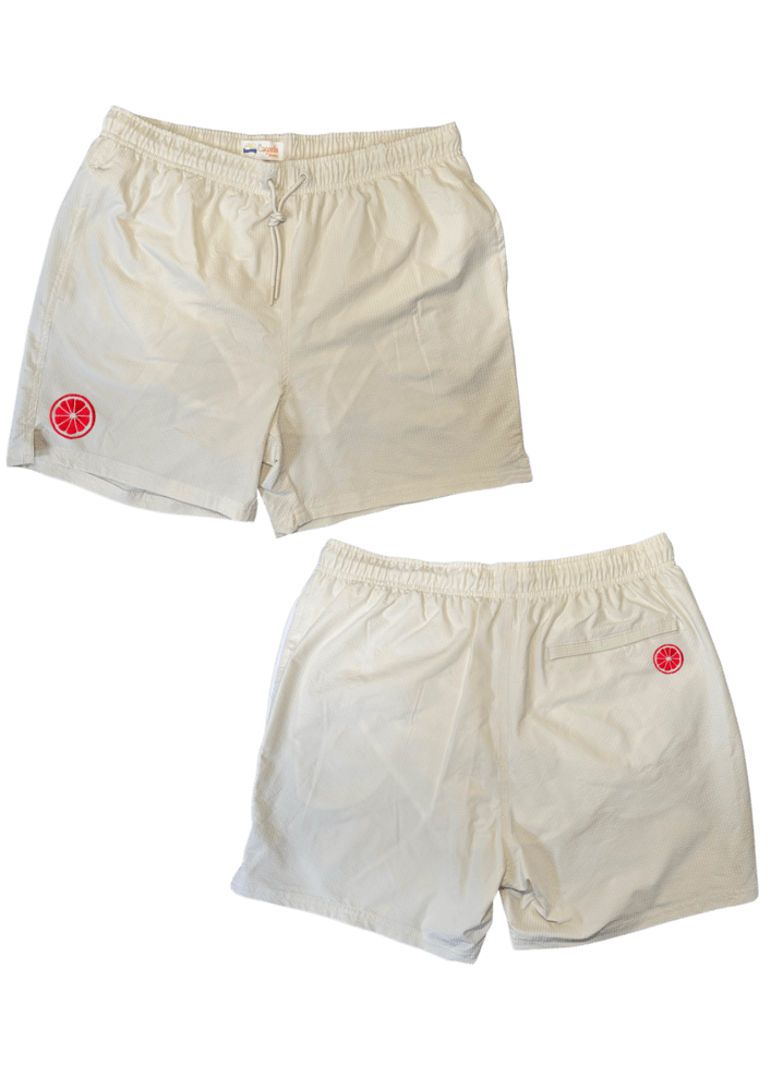 Maillot de plage pour homme couleur beige. Personnalisation du maillot grâce à des broderies. Il faut choisir parmi un choix de broderies dessinées à la main sur le thème de l’été sur la Côte d’Azur dans les Alpes Maritimes, 06. La broderie est brodée sur l’avant du maillot, jambe droite et sur la poche arrière jambe droite. Toutes les broderies sont faites à la commande selon la personnalisation choisie. Ici, il s’agit de la broderie pomelo, pamplemousse, agrume, rose flashy.