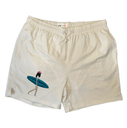 Maillot de plage pour homme couleur beige. Personnalisation du maillot grâce à des broderies. Il faut choisir parmi un choix de broderies dessinées à la main sur le thème de l’été sur la Côte d’Azur dans les Alpes Maritimes, 06. La broderie est brodée sur l’avant du maillot, jambe droite. Toutes les broderies sont faites à la commande selon la personnalisation choisie. Ici, il s’agit de la broderie surf, surfeuse, planche de surf.