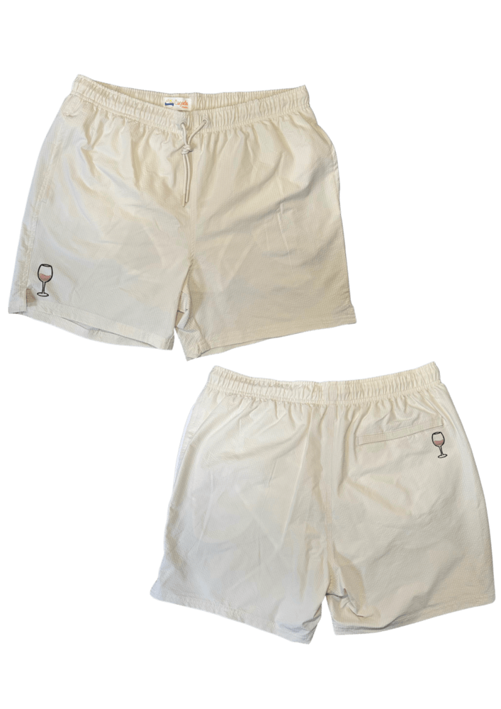 Maillot de plage pour homme couleur beige. Personnalisation du maillot grâce à des broderies. Il faut choisir parmi un choix de broderies dessinées à la main sur le thème de l’été sur la Côte d’Azur dans les Alpes Maritimes, 06. La broderie est brodée sur l’avant du maillot, jambe droite et sur la poche arrière jambe droite. Toutes les broderies sont faites à la commande selon la personnalisation choisie. Ici, il s’agit de la broderie verre de vin rosé.