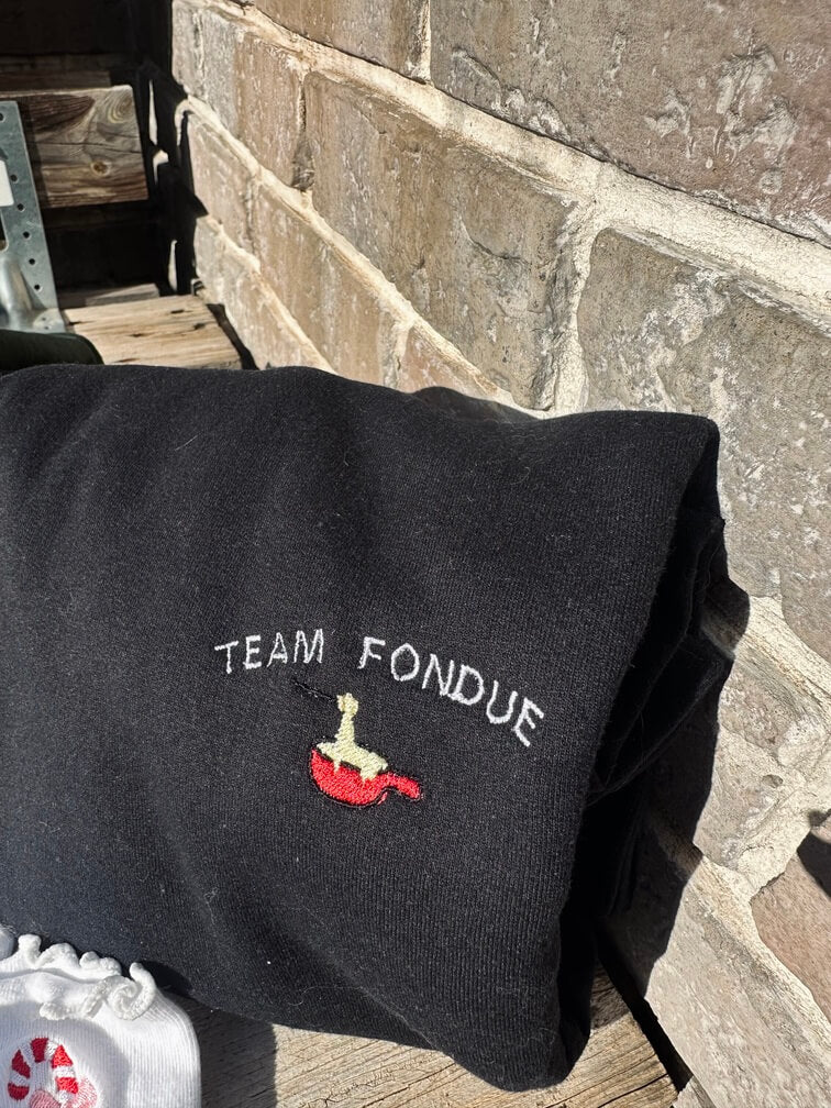 Sweatshirt tout doux hyper confortable loose avec broderie côté cœur et sur la manche droite personnalisation broderie team fondue. 
Texte TEAM FONDUE avec un appareil à fondue rouge et du fromage coulant idée cadeau à offrir personnalisation broderie. Broderie côté cœur plus broderie sur la manche droite. 