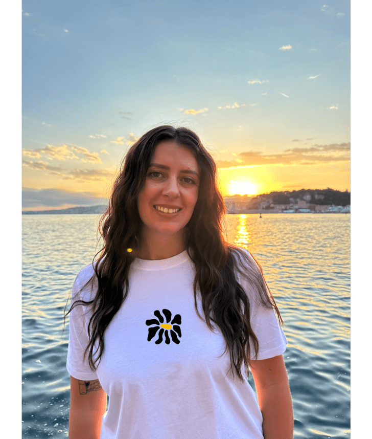 Modèle femme portant un t-shirt oversize blanc 100% coton avec une personnalisation de flocage DTF à l'avant au milieu d'une fleur noir.