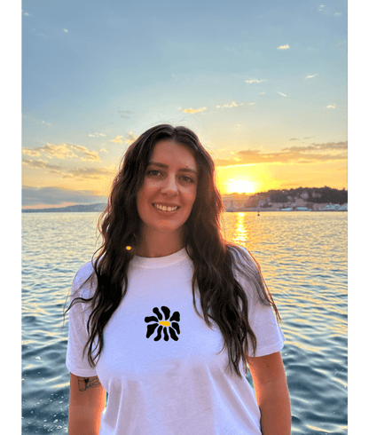 Modèle femme portant un t-shirt oversize blanc 100% coton avec une personnalisation de flocage DTF à l'avant au milieu d'une fleur noir.