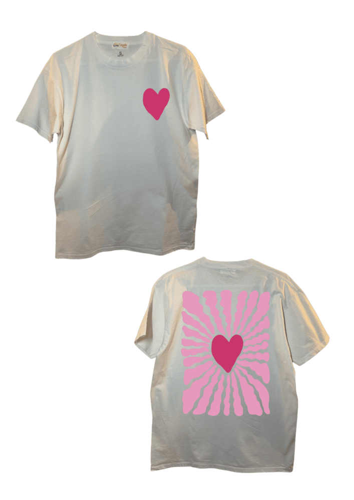 T-shirt oversize blanc, manche courte, 100% coton. Personnalisation du t-shirt grâce à une technique de flocage, le DTF, pour une meilleure qualité d’impression et de tenue. La personnalisation est floquée à l’avant au milieu en haut et à l’arrière en grand dans le dos. Ici, il s’agit de la personnalisation de DTF coeur rose avant et arrière.