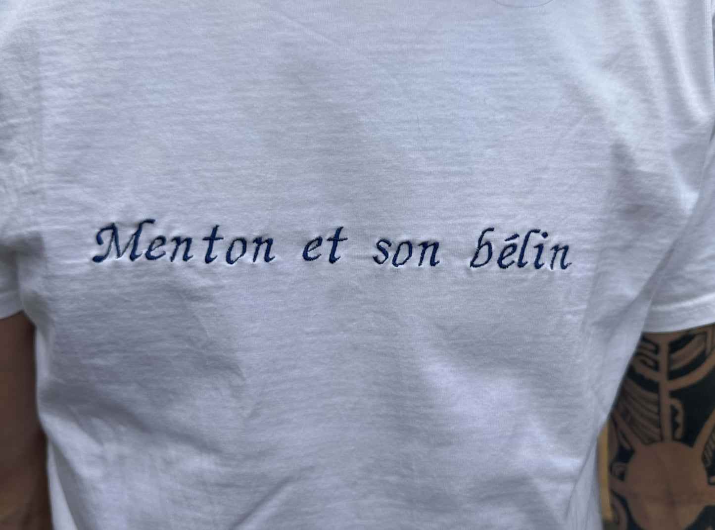 T-shirt oversize blanc homme, 100% coton. Personnalisation du t-shirt grâce à des broderies. Il faut choisir parmi un choix de broderies dessinées à la main sur le thème de l’été sur la Côte d’Azur dans les Alpes Maritimes, 06. Toutes les broderies sont faites à la commande selon la personnalisation choisie. Ici, il s’agit de la broderie "Menton et son bélin". Phrase typique de Menton Nice idée cadeau régional.