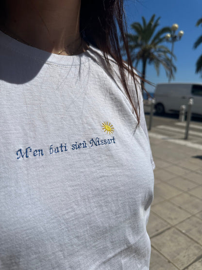T-shirt oversize blanc, 100% coton. Personnalisation du t-shirt grâce à des broderies. Il faut choisir parmi un choix de broderies dessinées à la main sur le thème de l’été sur la Côte d’Azur dans les Alpes Maritimes, 06. Toutes les broderies sont faites à la commande selon la personnalisation choisie. Ici, il s’agit de la broderie "m'en bati sieu Nissart" pour tous les niçois niçoises Nice