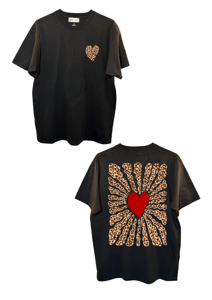 T-shirt oversize noir, manche courte, 100% coton. Personnalisation du t-shirt grâce à une technique de flocage, le DTF, pour une meilleure qualité d’impression et de tenue. La personnalisation est floquée à l’avant au milieu en haut et à l’arrière en grand dans le dos. Ici, il s’agit de la personnalisation de DTF coeur léopard à l'avant et coeur rouge avec soleil léopard à l'arrière.