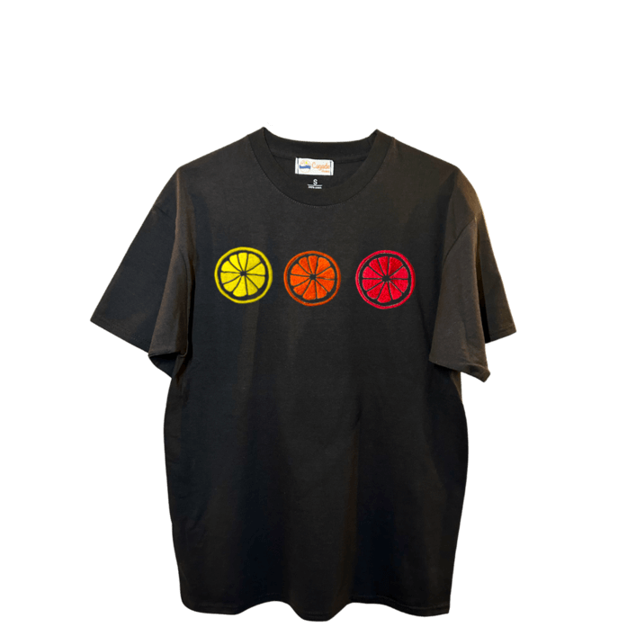 T-shirt oversize noir, 100% coton. Personnalisation du t-shirt grâce à des broderies. Il faut choisir parmi un choix de broderies dessinées à la main sur le thème de l’été sur la Côte d’Azur dans les Alpes Maritimes, 06. Il faut aussi choisir la position de la broderie entre à gauche côté cœur, à droite ou au milieu. Toutes les broderies sont faites à la commande selon la personnalisation choisie. Ici, il s’agit de la broderie 3 agrumes : citron, orange et pomelo, pamplemousse rose flashy.