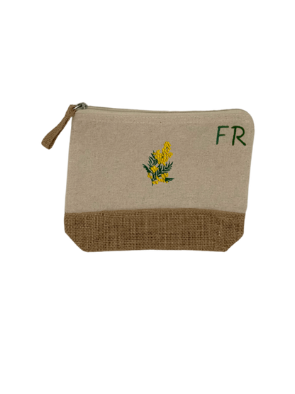 Trousse beige, écru, coton. Personnalisation de la trousse grâce à des broderies et initiales. Il faut choisir parmi un choix de broderies dessinées à la main sur le thème de l’été sur la Côte d’Azur dans les Alpes Maritimes, 06. Initiales brodées sur la trousse en haut à droite. Choix couleur du fil pour les initiales, personnalisation unique. Toutes les broderies sont faites à la commande selon la personnalisation choisie. Ici, il s’agit de la broderie mimosa, jaune et vert.