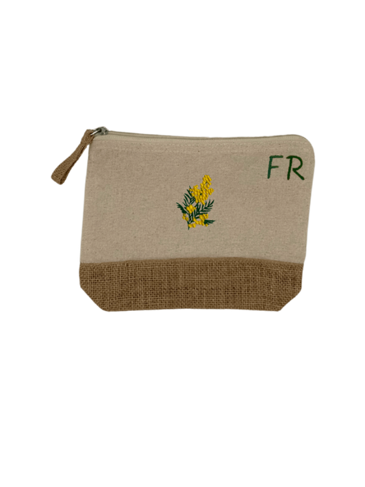 Trousse beige, écru, coton. Personnalisation de la trousse grâce à des broderies et initiales. Il faut choisir parmi un choix de broderies dessinées à la main sur le thème de l’été sur la Côte d’Azur dans les Alpes Maritimes, 06. Initiales brodées sur la trousse en haut à droite. Choix couleur du fil pour les initiales, personnalisation unique. Toutes les broderies sont faites à la commande selon la personnalisation choisie. Ici, il s’agit de la broderie mimosa, jaune et vert.